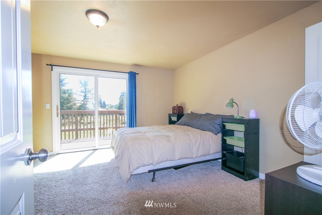 27615 Webster Road East Graham, WA 98338 - Photo 23 of 36 a bedroom with a bed a mirror and a large window
