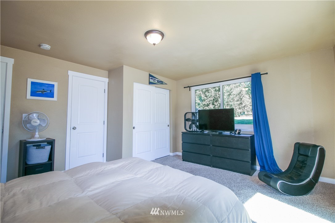 27615 Webster Road East Graham, WA 98338 - Photo 24 of 36 a bedroom with a bed and a mirror