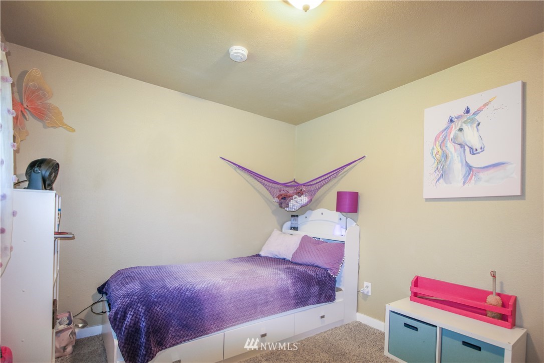 27615 Webster Road East Graham, WA 98338 - Photo 29 of 36 a bedroom with a bed and a chandelier