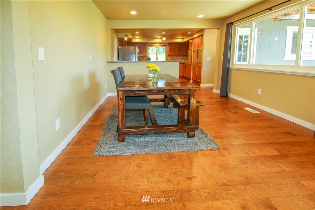 27615 Webster Road East Graham, WA 98338 - Photo 10 of 36 a dining room with wooden floor