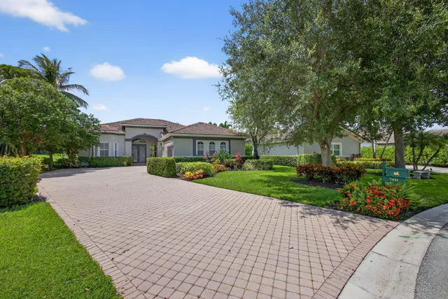 a front view of a house with a yard and potted plants