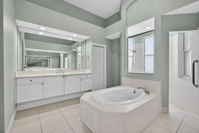 a bathroom with a tub sink and mirror