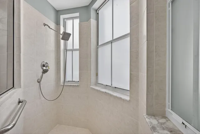 an empty room with wooden floor chandelier fan and windows