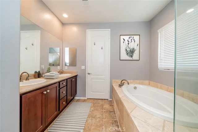 a spacious bathroom with a tub sink and mirror