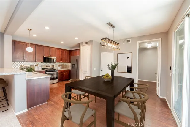 a kitchen with a table chairs refrigerator and microwave