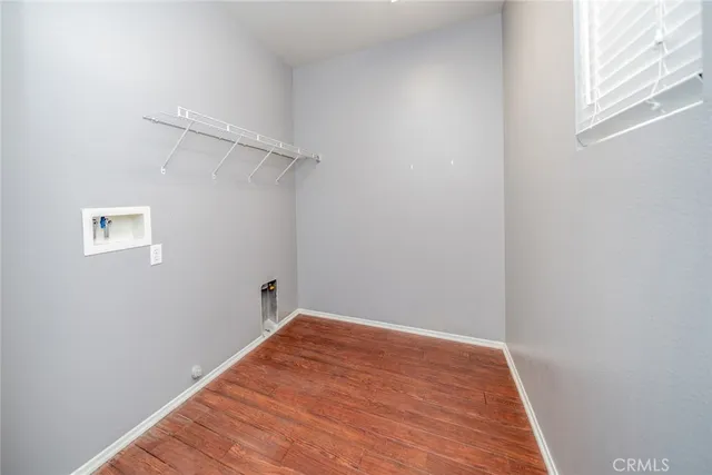 a view of a small space with wooden floor and a window
