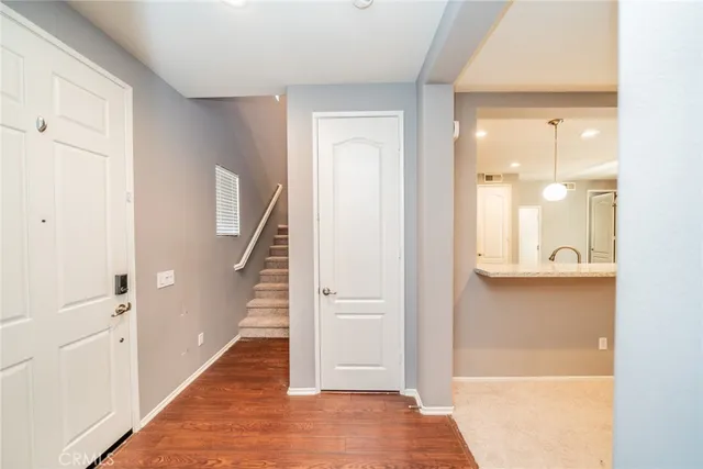a view of a hallway with wooden floor and staircase