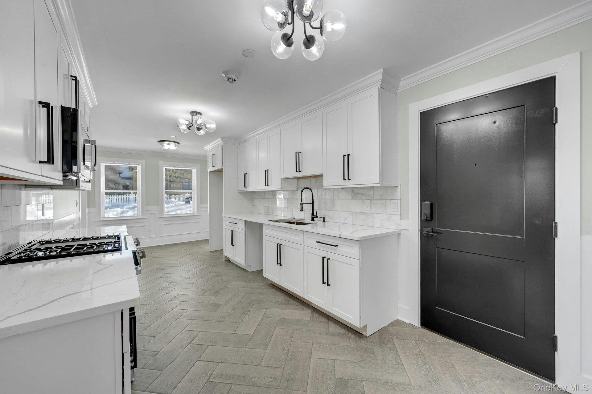 74 Nelson Avenue, Unit 1 Harrison, NY 10528 - Photo 3 of 15 a kitchen with stainless steel appliances a refrigerator sink and cabinets