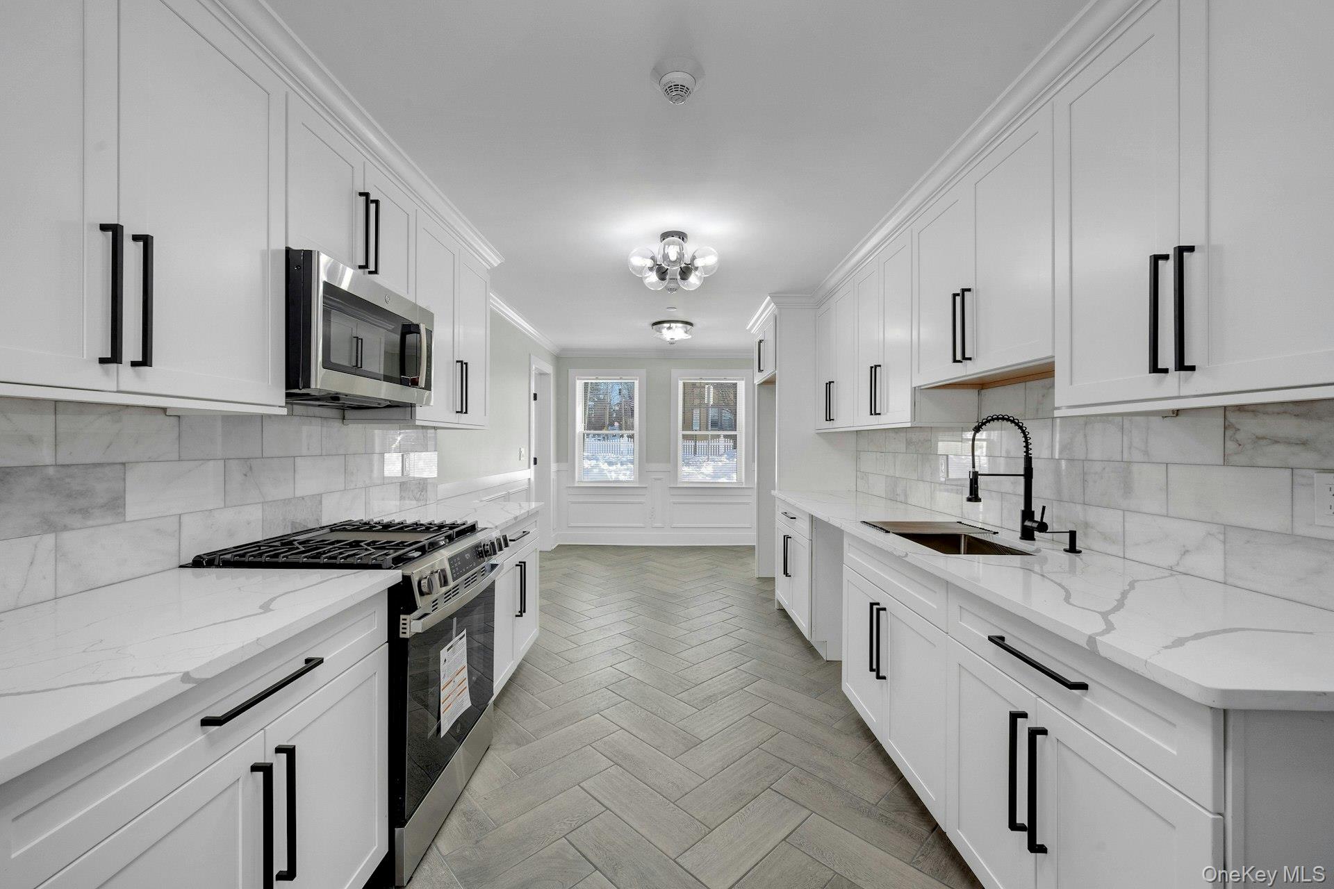 74 Nelson Avenue, Unit 1 Harrison, NY 10528 - Photo 5 of 15 a kitchen with stainless steel appliances granite countertop a sink stove microwave and cabinets