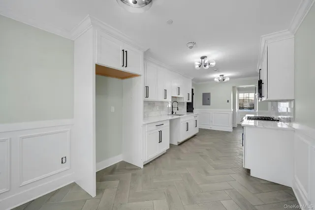 a large white kitchen with cabinets and stainless steel appliances