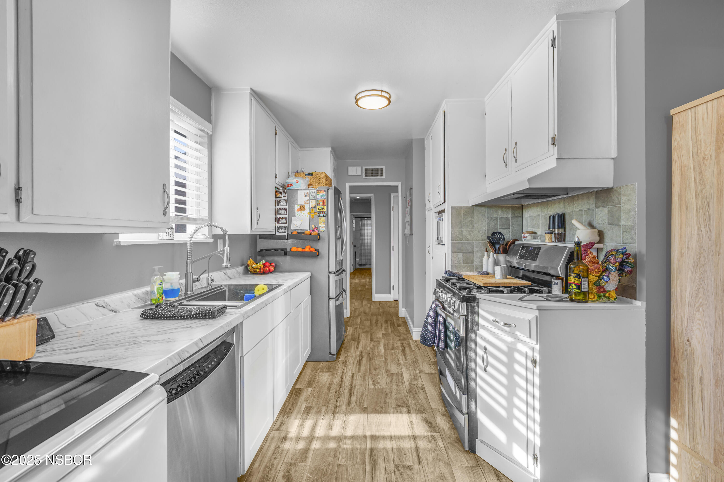 3939 Saturn Avenue Lompoc, CA 93436 - Photo 10 of 26 a kitchen filled with a white stove top oven a sink a counter space and stainless steel appliances