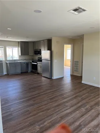 a kitchen with stainless steel appliances wooden floor and large window