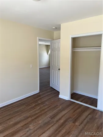an empty room with wooden floor & closet
