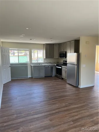 a room with stainless steel appliances wooden floors and view living room