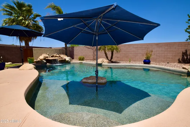 a view of a patio with chairs under an umbrella