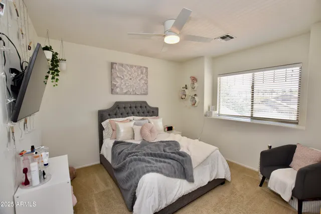 a bedroom with a bed flat screen tv and a couch