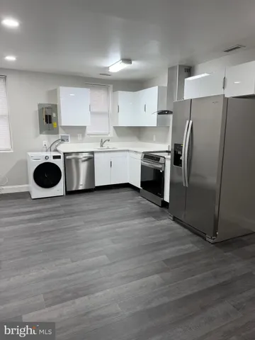 a kitchen with a refrigerator sink and cabinets
