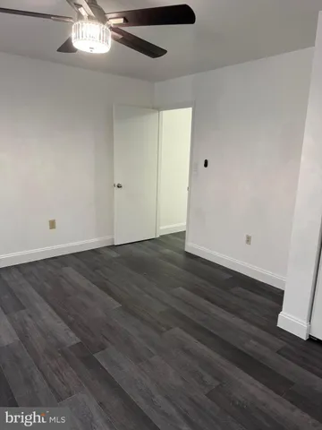 an empty room with wooden floor and chandelier fan
