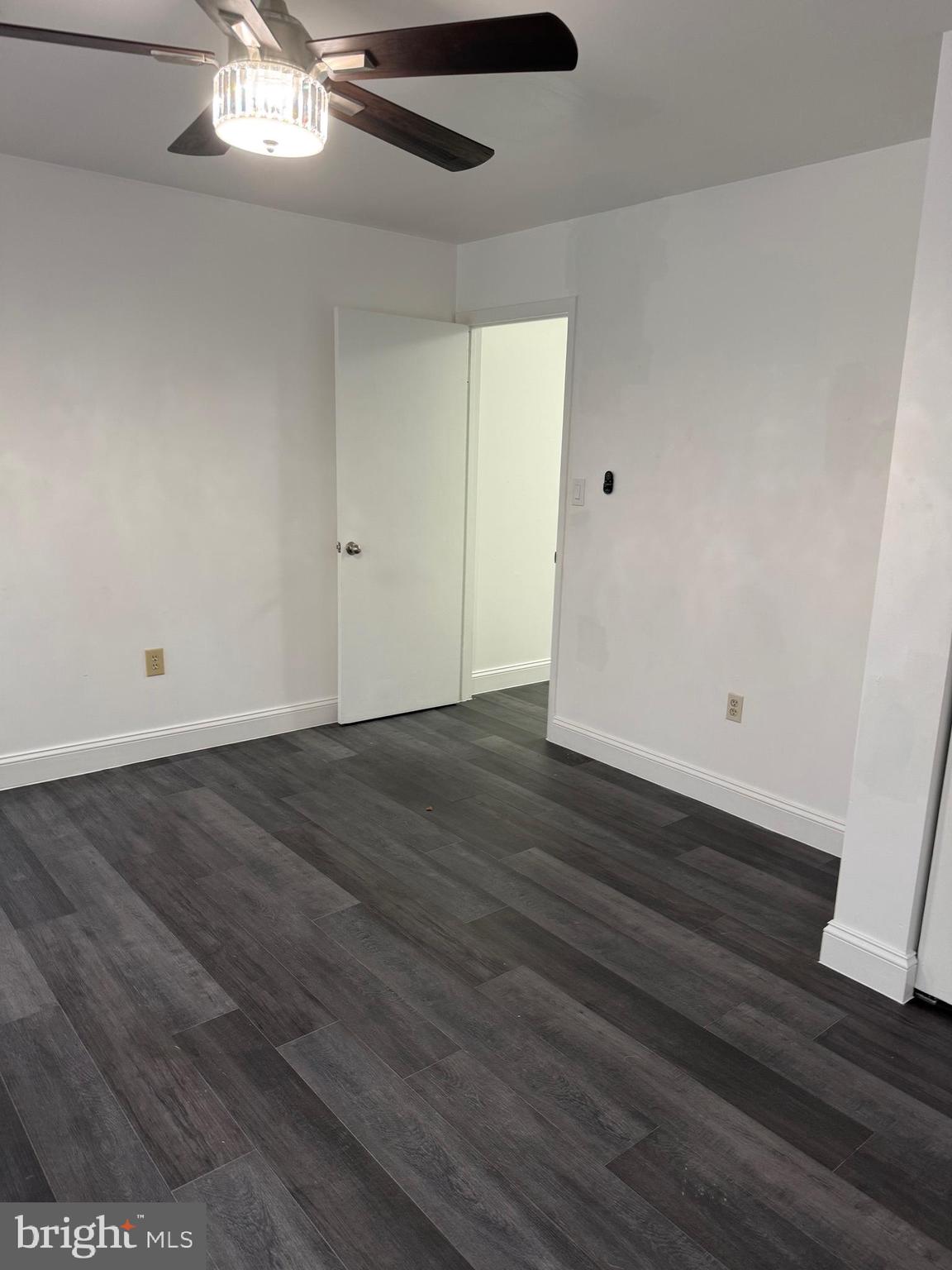 2511 Maryland Avenue, Unit 3 Baltimore, MD 21218 - Photo 8 of 11 an empty room with wooden floor and chandelier fan