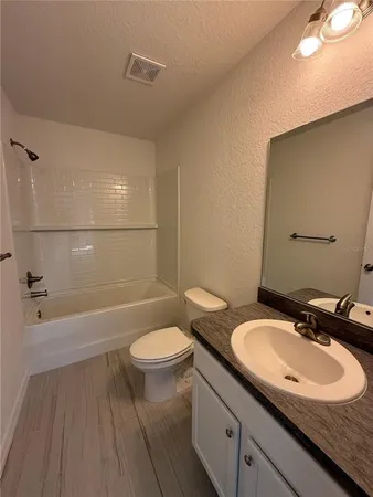 a bathroom with a sink a toilet a mirror and bathtub