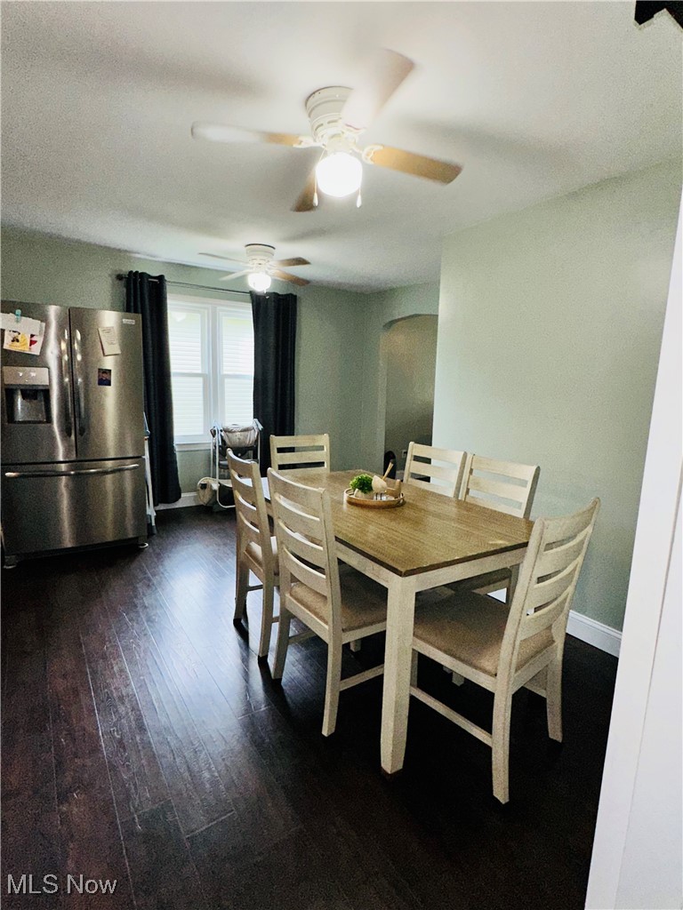 418 Main Street Philo, OH 43771 - Photo 15 of 37 Dining area featuring arched walkways, a ceiling fan, dark wood-style flooring, and baseboards