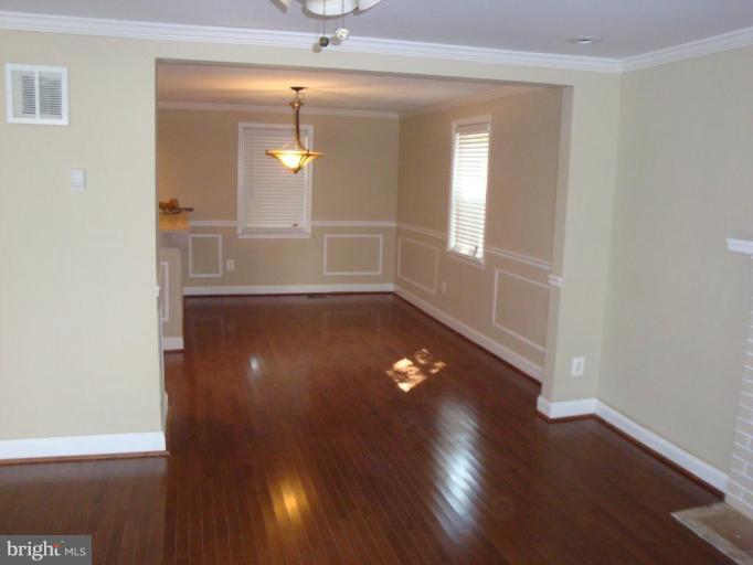 5749 Maplehill Road Baltimore, MD 21239 - Photo 1 of 15 an empty room with wooden floor and windows
