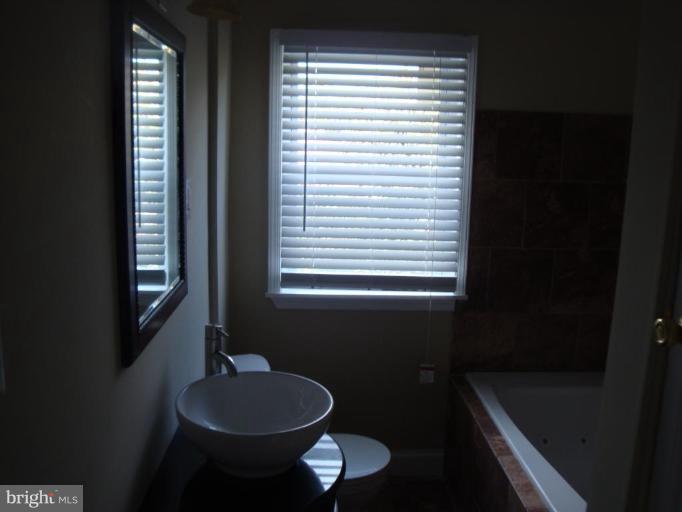 5749 Maplehill Road Baltimore, MD 21239 - Photo 11 of 15 a bathroom with a toilet a sink and a window