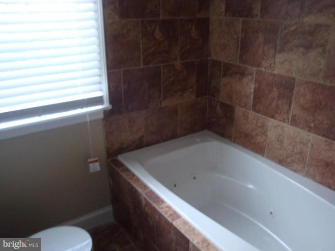 5749 Maplehill Road Baltimore, MD 21239 - Photo 12 of 15 a bathroom with a bathtub and toilet