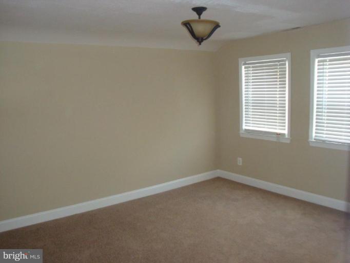 5749 Maplehill Road Baltimore, MD 21239 - Photo 13 of 15 an empty room with a window and a fan