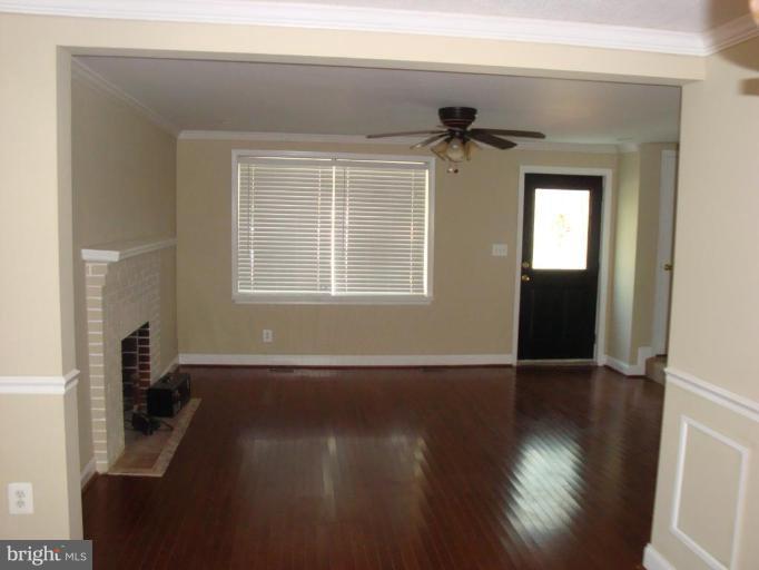 5749 Maplehill Road Baltimore, MD 21239 - Photo 3 of 15 an empty room with wooden floor and windows