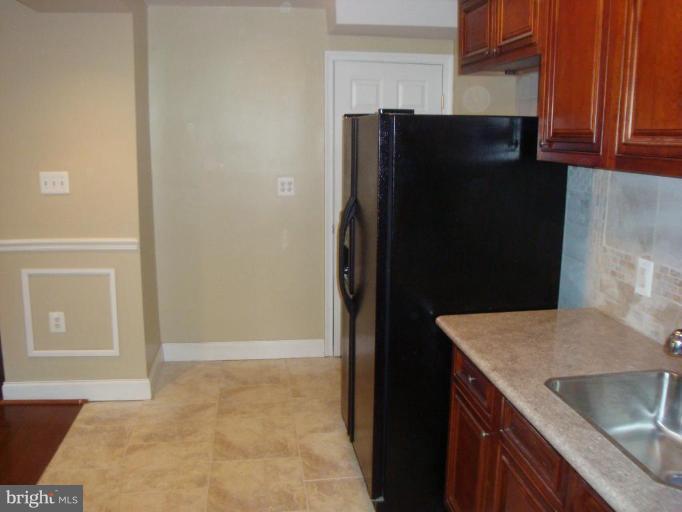 5749 Maplehill Road Baltimore, MD 21239 - Photo 8 of 15 a kitchen with a refrigerator and a sink