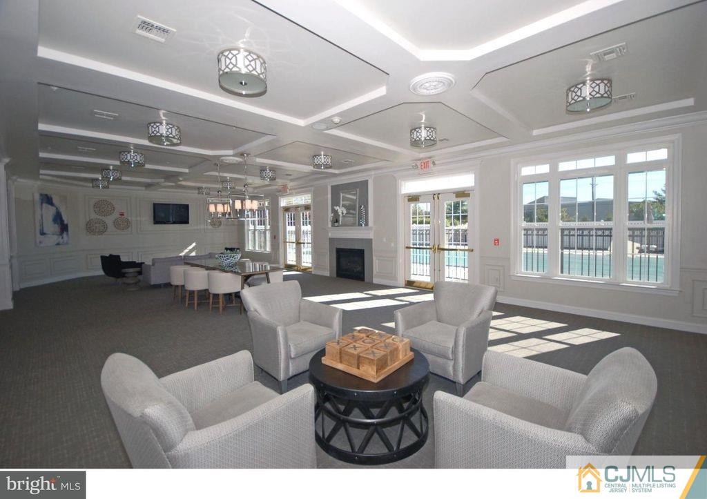 100 Middlesex Boulevard Plainsboro, NJ 08536 - Photo 3 of 11 a living room with furniture a fireplace and a large window