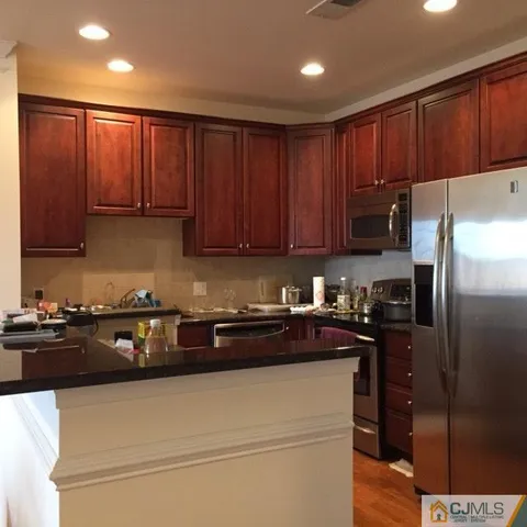 a kitchen with a sink a refrigerator and cabinets
