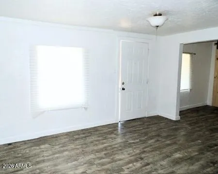 a view of an empty room with closet and a window