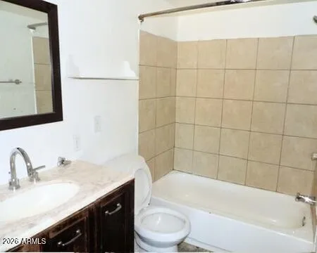 a bathroom with a granite countertop bathtub sink vanity mirror and toilet