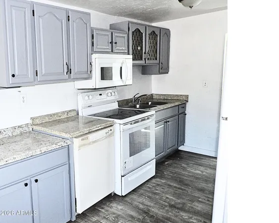 a kitchen with stainless steel appliances granite countertop a stove a sink and white cabinets