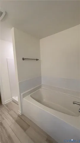 a white bath tub sitting next to a shower