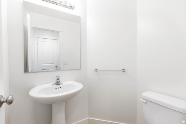 3157 Deseret Drive St. George, UT 84790 - Photo 9 of 24 Pedestal sink with chrome faucet, large rectangular mirror, and overhead vanity lighting