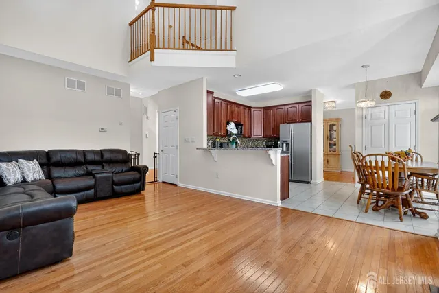 a living room with furniture and kitchen view with wooden floor