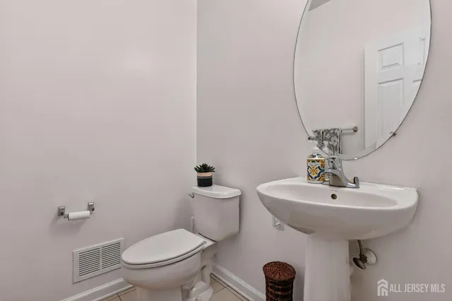 a bathroom with a sink toilet and a mirror