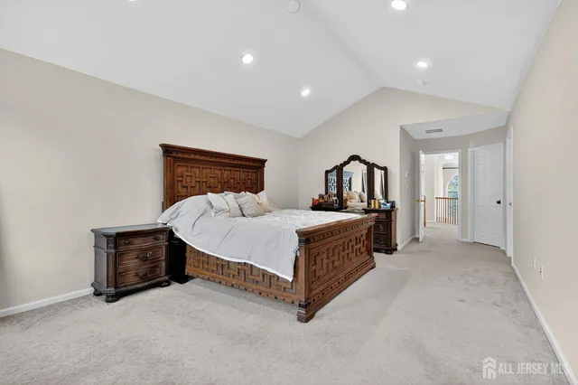 a spacious bedroom with a bed lamp and a dresser
