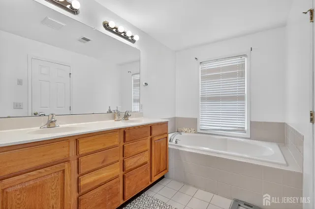 a bathroom with a tub sink and mirror