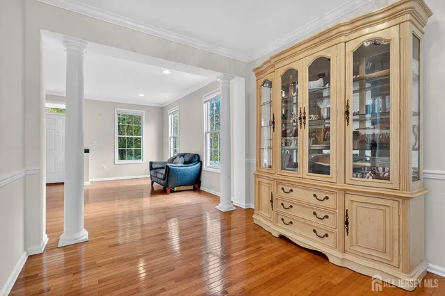 a living room with furniture cabinets and wooden floor