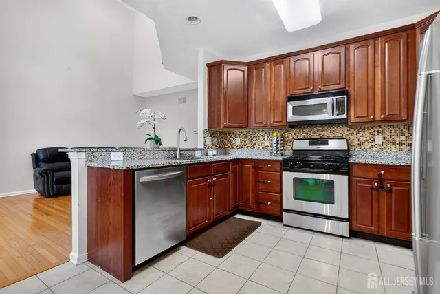 a kitchen with stainless steel appliances granite countertop a stove microwave and sink