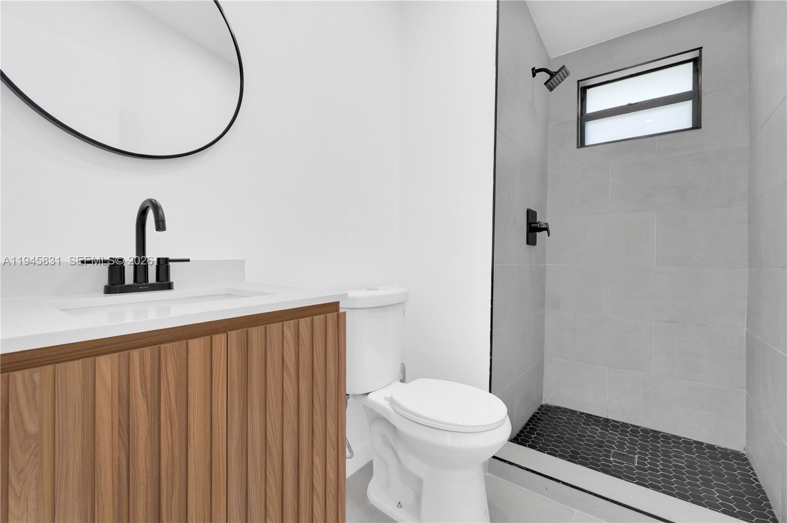 3040 Northwest 93rd Street, Unit D Miami, FL 33147 - Photo 8 of 8 a bathroom with a sink and a mirror