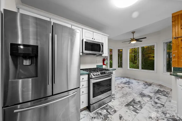 a kitchen with stainless steel appliances granite countertop a refrigerator and a stove top oven
