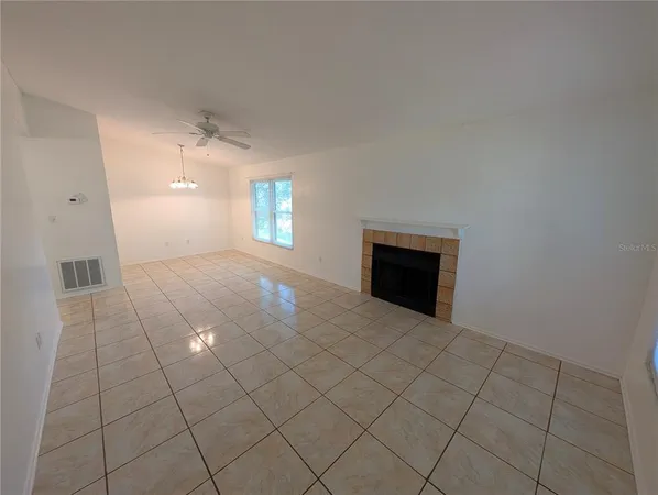 an empty room with a ceiling fan and a window