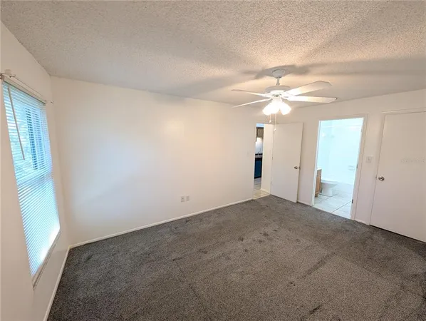 a view of a livingroom with a chandelier fan and closet area