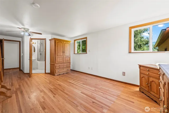 a view of empty room with wooden floor and window