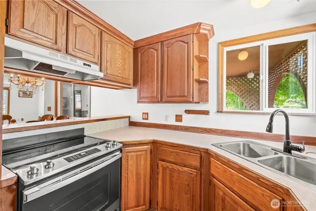 a kitchen with stainless steel appliances granite countertop a sink a stove and cabinets